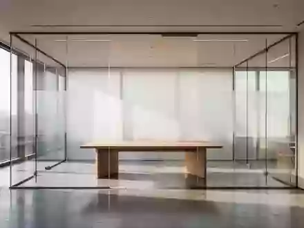 Ein minimalistisch gestalteter, leerer Konferenzraum mit bodentiefen Fenstern, hellem Tageslicht und einem schlichten Holztisch. - Foto: über boerse-global.de