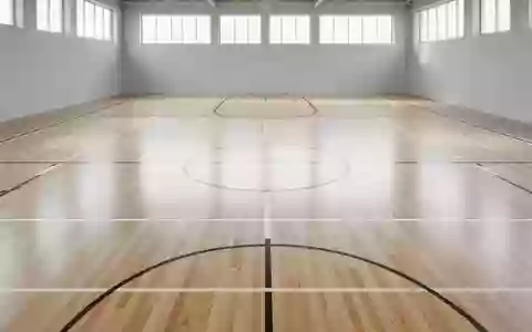 Leere, helle Sporthalle mit poliertem Holzboden und geometrischen Bodenmarkierungen in einer minimalistischen Umgebung. - Foto: über boerse-global.de
