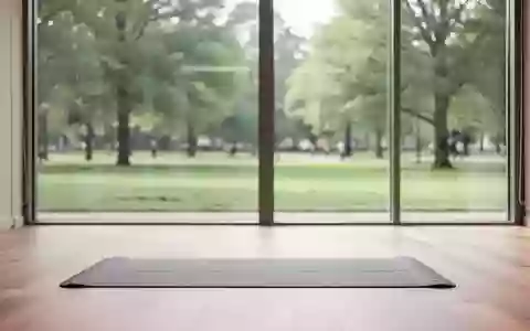 Ein heller, minimalistischer Physiotherapieraum mit Holzboden und einer leeren Gymnastikmatte vor einer Fensterfront. - Foto: über boerse-global.de
