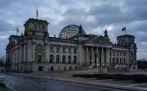 Das Berliner Reichstagsgebäude in der Abenddämmerung bei bewölktem Himmel. - Foto: über boerse-global.de