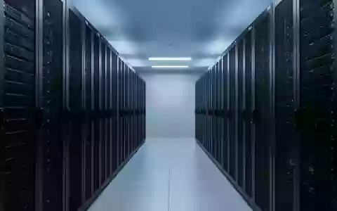 Ein moderner, minimalistischer Serverraum mit symmetrischen, leeren Serverschränken in einer kühlen, blauen Beleuchtung. - Foto: über boerse-global.de
