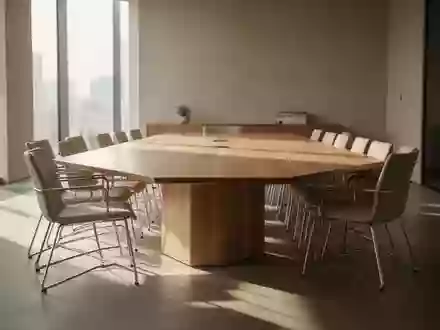 Ein minimalistischer Konferenzraum mit einem Holztisch und leeren Stühlen in hellem, natürlichem Licht. - Foto: über boerse-global.de