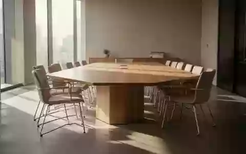 Ein minimalistischer Konferenzraum mit einem Holztisch und leeren Stühlen in hellem, natürlichem Licht. - Foto: über boerse-global.de