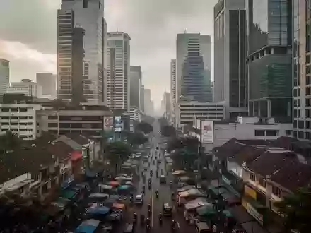 Blick auf ein Finanzviertel in Jakarta mit modernen Hochhäusern und geschäftigem Treiben unter bewölktem Himmel. - Foto: über boerse-global.de