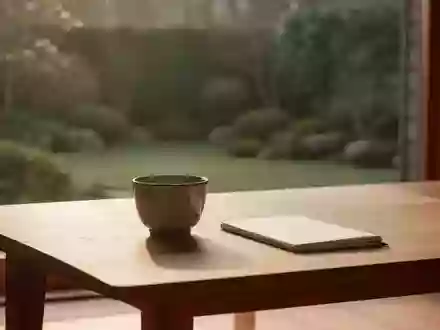 Ein minimalistischer Holztisch mit einer Keramiktasse in sanftem Morgenlicht vor einem ruhigen Gartenblick. - Foto: über boerse-global.de
