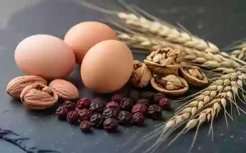 Nahaufnahme von unverarbeiteten Lebensmitteln wie Eiern, Nüssen und Beeren auf einem dunklen Steinhintergrund. - Foto: über boerse-global.de