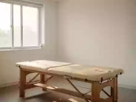 Ein minimalistischer Behandlungsraum in einer Klinik mit einer hölzernen Massageliege und hellem Tageslicht. - Foto: über boerse-global.de