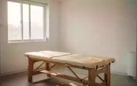 Ein minimalistischer Behandlungsraum in einer Klinik mit einer hölzernen Massageliege und hellem Tageslicht. - Foto: über boerse-global.de