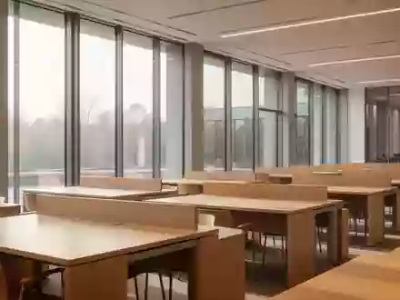Ein minimalistischer, leerer Universitäts-Lesesaal mit hellen Holztischen und natürlichem Tageslicht. - Foto: über boerse-global.de