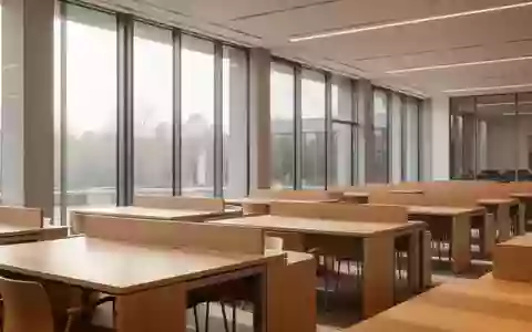 Ein minimalistischer, leerer Universitäts-Lesesaal mit hellen Holztischen und natürlichem Tageslicht. - Foto: über boerse-global.de