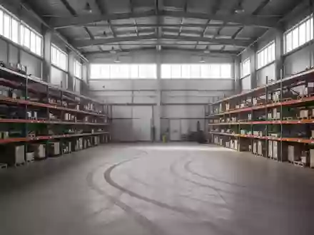 Leeres, aufgeräumtes Lagerhaus mit hohen Regalen und Betonboden in einer Industriehalle. - Foto: über boerse-global.de