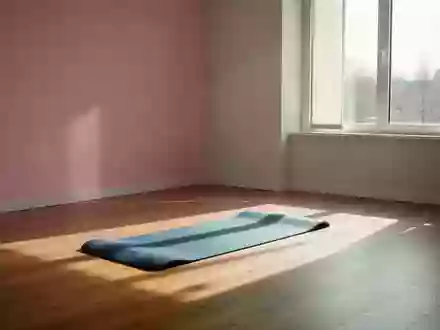 Ein minimalistisch eingerichteter, sonnendurchfluteter Therapieraum mit einer einzelnen Gymnastikmatte auf einem Holzboden. - Foto: über boerse-global.de