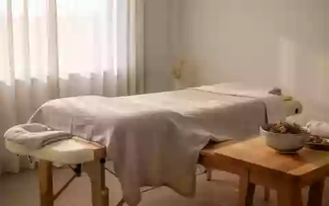 Ein minimalistischer Behandlungsraum einer TCM-Praxis mit einer schlichten Massageliege und natürlichen Materialien. - Foto: über boerse-global.de