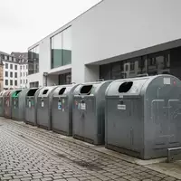 Leere öffentliche Müllbehälter vor einer städtischen Kulisse in Freiburg als Symbol für die Debatte zur Verpackungssteuer. - Foto: über boerse-global.de