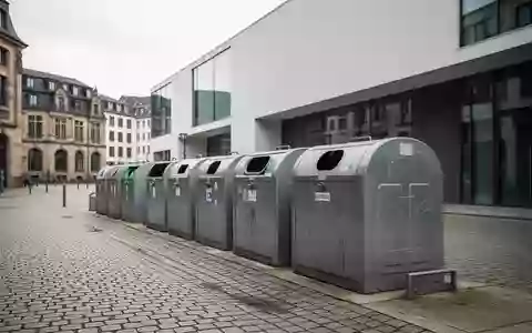 Leere öffentliche Müllbehälter vor einer städtischen Kulisse in Freiburg als Symbol für die Debatte zur Verpackungssteuer. - Foto: über boerse-global.de
