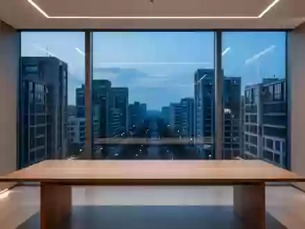 Ein minimalistisch gestalteter, leerer Büroarbeitsplatz mit Blick auf eine städtische Architektur bei Dämmerung. - Foto: über boerse-global.de
