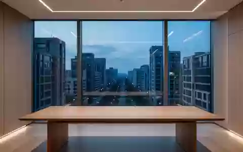 Ein minimalistisch gestalteter, leerer Büroarbeitsplatz mit Blick auf eine städtische Architektur bei Dämmerung. - Foto: über boerse-global.de