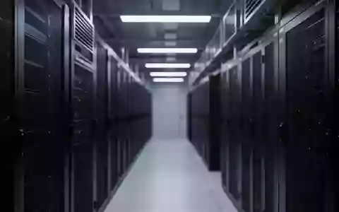 Ein moderner, minimalistischer Serverraum mit dunklen Metall-Serverracks und kühler industrieller Beleuchtung. - Foto: über boerse-global.de