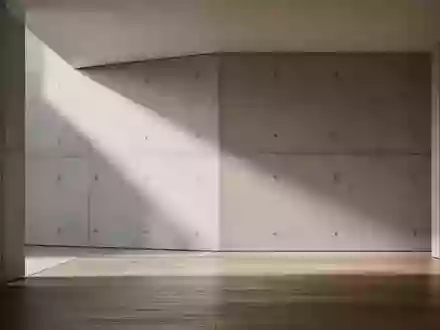 Ein minimalistischer, moderner Innenraum mit klaren geometrischen Linien und natürlichem Lichteinfall auf Beton und Holz. - Foto: über boerse-global.de
