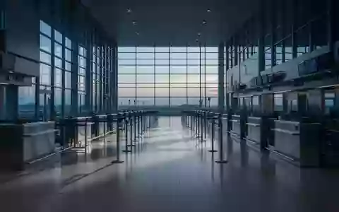 Leerer Check-in-Bereich eines Flughafens mit langen, unbesetzten Schaltern in kühlem, natürlichem Licht. - Foto: über boerse-global.de