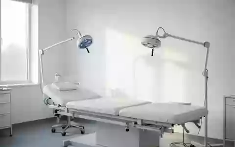 Ein minimalistischer, heller medizinischer Behandlungsraum mit einer Untersuchungsliege und einer Diagnostikleuchte. - Foto: über boerse-global.de