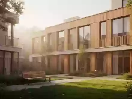 Modernes Wohngebäude mit Holzfassade und Gemeinschaftsgarten in einer freundlichen Wohnsiedlung. - Foto: über boerse-global.de