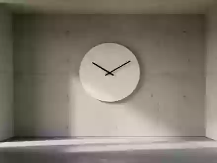 Eine minimalistische Wanduhr an einer schlichten Betonwand in einem hellen, leeren Raum. - Foto: über boerse-global.de