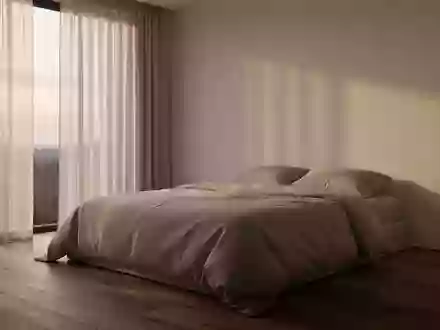 Ein minimalistisch eingerichtetes Schlafzimmer mit einem unbenutzten, ordentlich gemachten Bett im sanften Morgenlicht. - Foto: über boerse-global.de