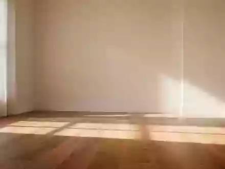 Ein lichtdurchfluteter, minimalistischer Raum mit sanftem Schattenwurf auf einem Holzboden, der Ruhe und Ausgeglichenheit vermittelt. - Foto: über boerse-global.de