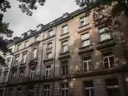 Ein unbewohnt wirkendes, mehrstöckiges Gebäude in einer deutschen Stadt bei bewölktem Himmel. - Foto: über boerse-global.de