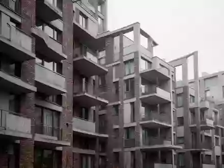 Fassade eines modernen Wohnblocks mit Balkonen an einem bewölkten Tag. - Foto: über boerse-global.de