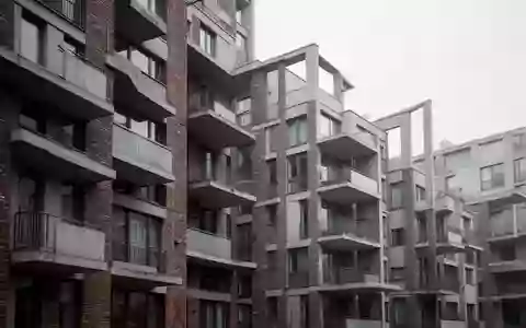 Fassade eines modernen Wohnblocks mit Balkonen an einem bewölkten Tag. - Foto: über boerse-global.de