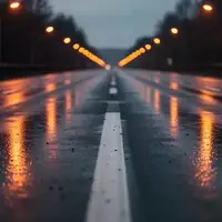 Eine menschenleere, nasse Asphaltstraße bei Dämmerung mit reflektierenden Fahrbahnmarkierungen und verschwommenen Straßenlaternen. - Foto: über boerse-global.de