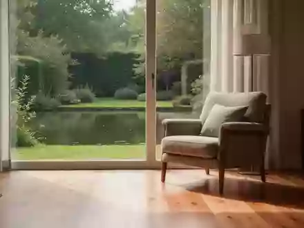 Ein sonnendurchflutetes Wohnzimmer mit einem bequemen Sessel und Blick in einen ruhigen Garten. - Foto: über boerse-global.de