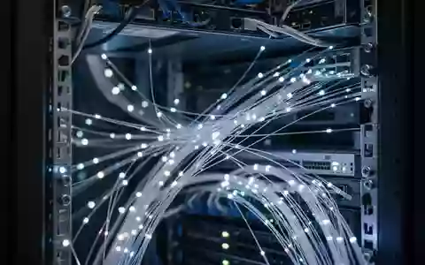 Nahaufnahme von Glasfaserkabeln in einem modernen Serverraum mit blauer Beleuchtung. - Foto: über boerse-global.de