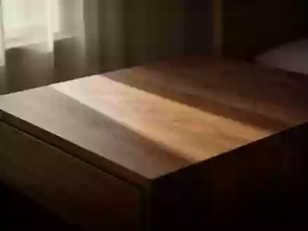 Ein minimalistischer Holznachttisch in gedimmtem, natürlichem Morgenlicht mit weichen Schatten. - Foto: über boerse-global.de