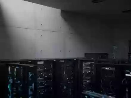 Ein minimalistischer, architektonisch gestalteter Raum mit Sichtbetonwand und im Hintergrund verschwommener Servertechnik. - Foto: über boerse-global.de