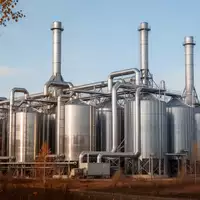 Industrielle Ölmühle mit Edelstahlsilos und Lüftungsrohren vor klarem Himmel - Foto: über boerse-global.de