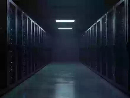 Dunkler, minimalistischer Serverraum mit unbeleuchteten Metall-Serverracks in einer kühlen, technologischen Umgebung. - Foto: über boerse-global.de
