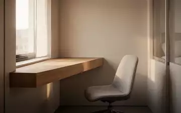 Ein minimalistisch gestalteter Arbeitsbereich in einer kleinen Wohnung mit hellem Holz und natürlichem Lichteinfall. - Foto: über boerse-global.de