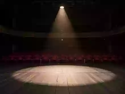 Eine leere Theaterbühne im Halbdunkel, die die Atmosphäre der kulturellen Unsicherheit widerspiegelt. - Foto: über boerse-global.de