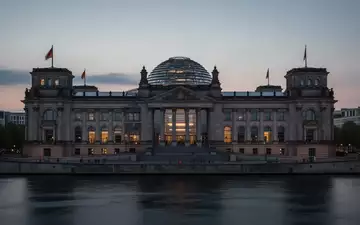 Das Reichstagsgebäude in Berlin in der Abenddämmerung, gesehen über die Spree. - Foto: über boerse-global.de