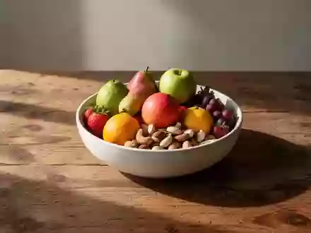 Eine Schale mit frischem Obst und Nüssen auf einem Holztisch bei natürlichem Morgenlicht. - Foto: über boerse-global.de