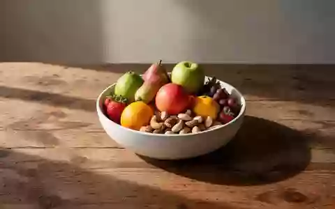 Eine Schale mit frischem Obst und Nüssen auf einem Holztisch bei natürlichem Morgenlicht. - Foto: über boerse-global.de