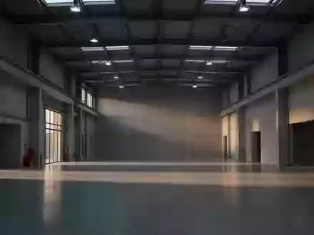 Eine leere, moderne Industriehalle bei Dämmerlicht mit klaren architektonischen Linien und natürlichem Lichteinfall. - Foto: über boerse-global.de