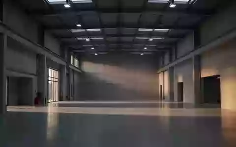 Eine leere, moderne Industriehalle bei Dämmerlicht mit klaren architektonischen Linien und natürlichem Lichteinfall. - Foto: über boerse-global.de