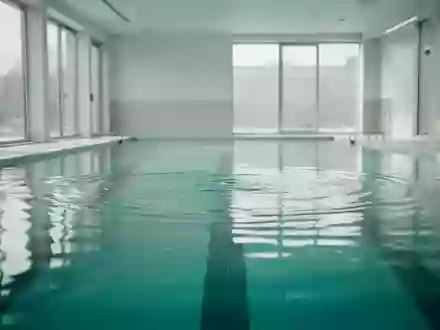 Ein ruhiges, helles Schwimmbecken mit klarem Wasser und sanften Lichtreflexionen an der Oberfläche. - Foto: über boerse-global.de