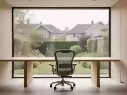 Ein minimalistisch eingerichtetes Heimbüro mit einem leeren Schreibtisch und Blick in einen Garten bei natürlichem Tageslicht. - Foto: über boerse-global.de