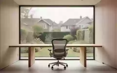 Ein minimalistisch eingerichtetes HeimbĂĽro mit einem leeren Schreibtisch und Blick in einen Garten bei natĂĽrlichem Tageslicht. - Foto: ĂĽber boerse-global.de