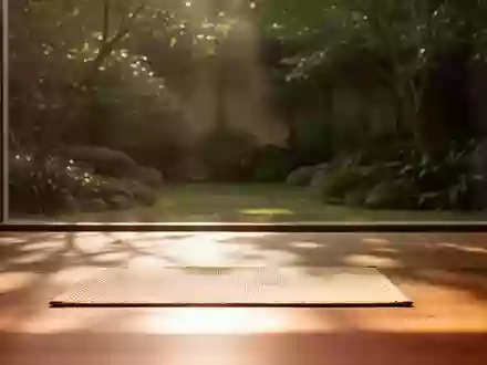 Ein heller, minimalistischer Übungsraum mit Holzboden, einer einzelnen Matte und sanftem Tageslicht, das auf eine Gartenanlage fällt. - Foto: über boerse-global.de